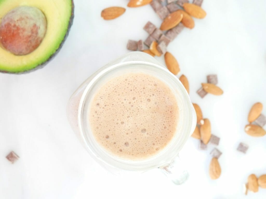 A chocolate almond butter smoothie with protein from above with avocado and almonds