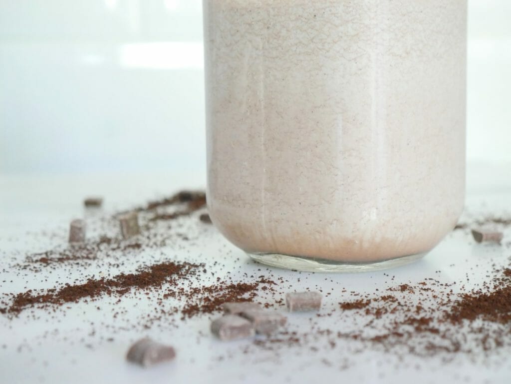The bottom of a Keto mocha smoothie with coffee grounds spread around