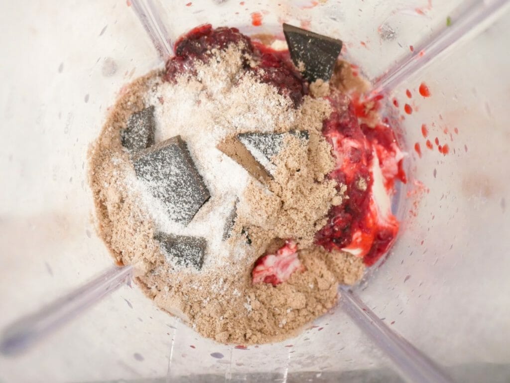 Mixed berry protein smoothie ingredients in a blender