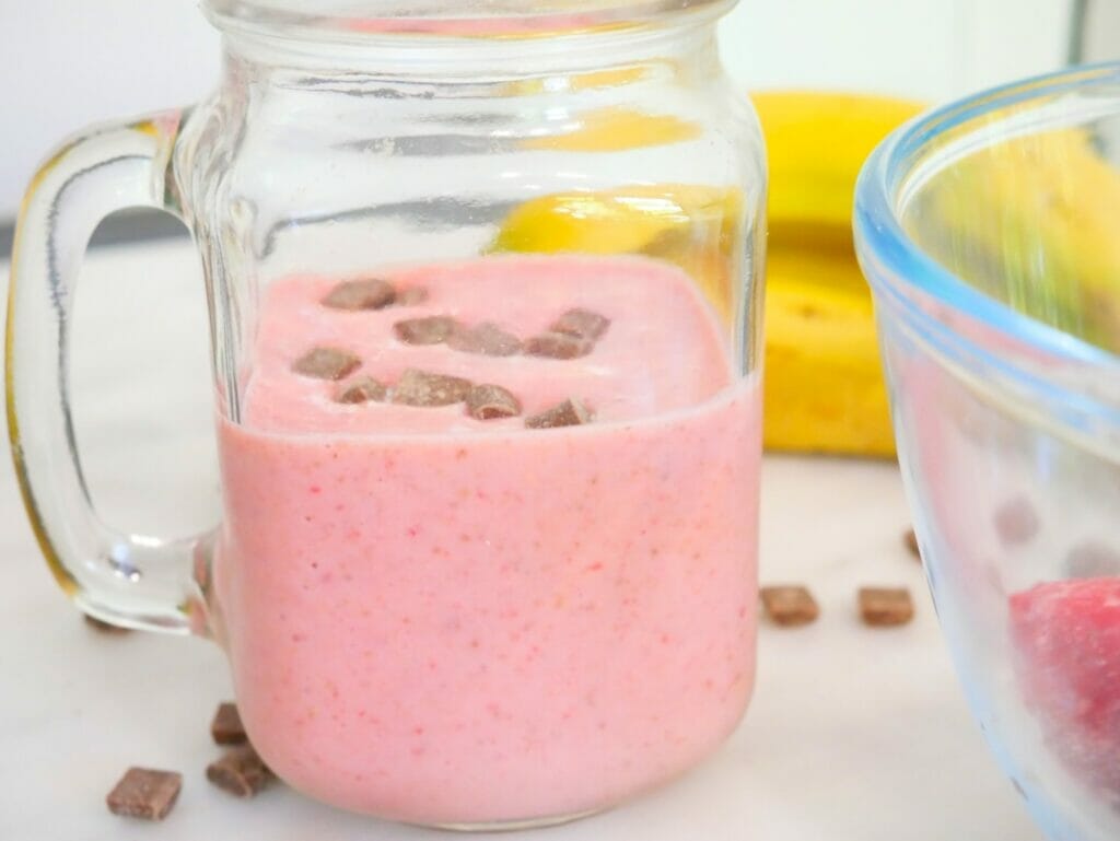 strawberry banana smoothie ingredients with smoothie in front