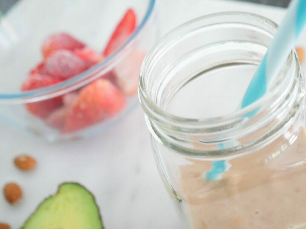 A coconut milkshake with strawberries and avocado and almonds