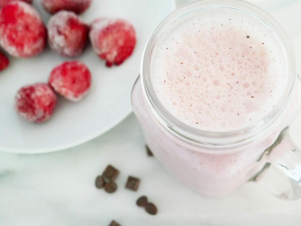 Coconut and strawberry smoothie with strawberries displayed