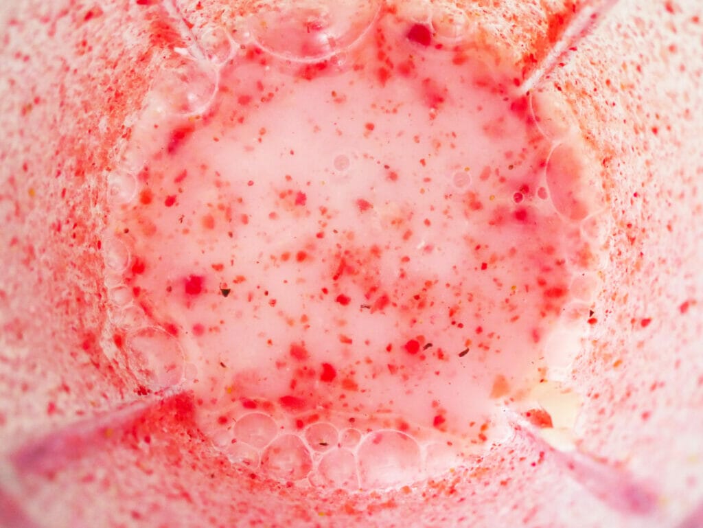 Keto strawberry coconut smoothie ingredients in a blender