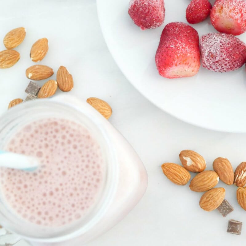 Strawberry protein shake weight loss smoothie with strawberries, almonds, and chocolate chips seen from above