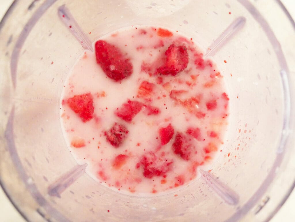 Strawberries and coconut milk in blender