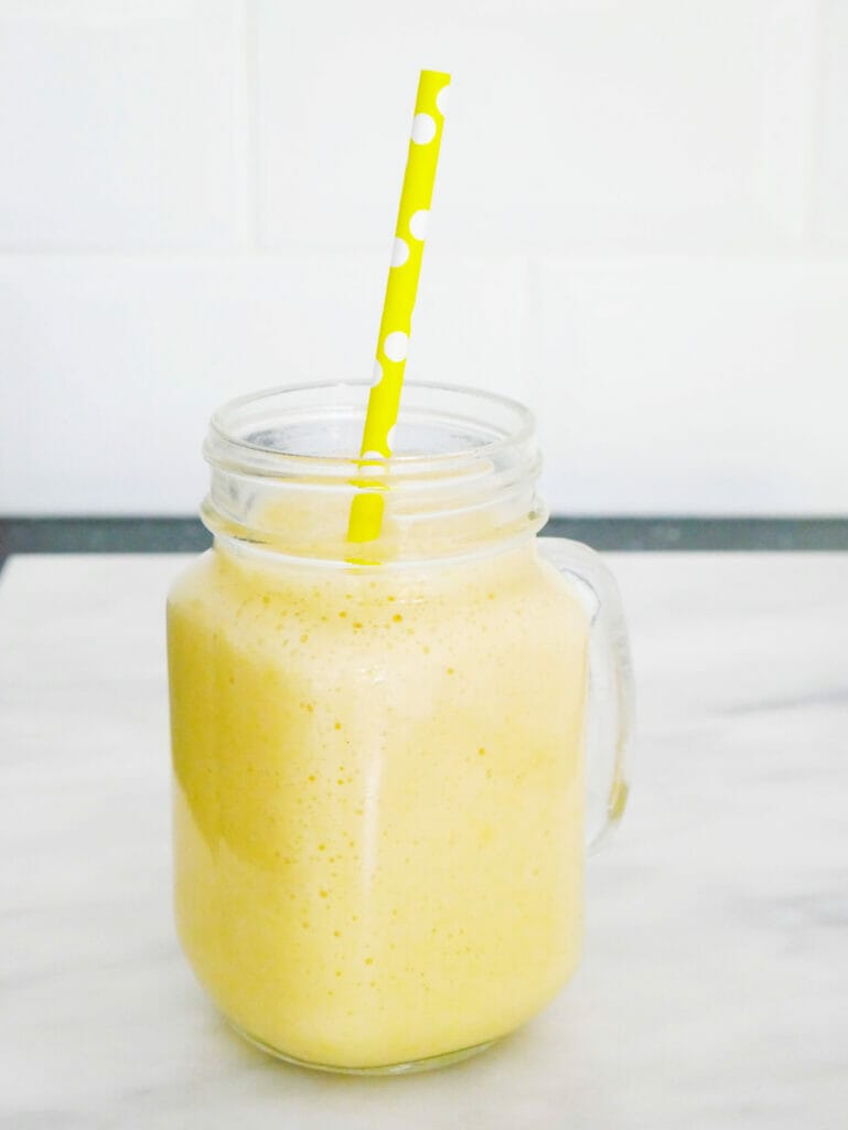 Mango pineapple and coconut smoothie with yellow straw