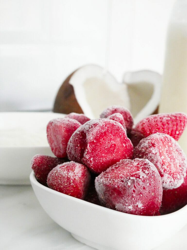 Frozen strawberries with coconut behind