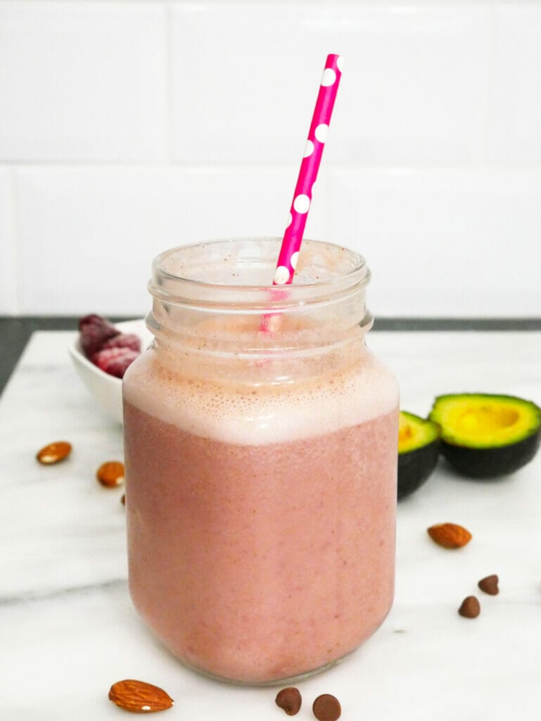 Chocolate raspberry smoothie weight gainer shake with ingredients behind