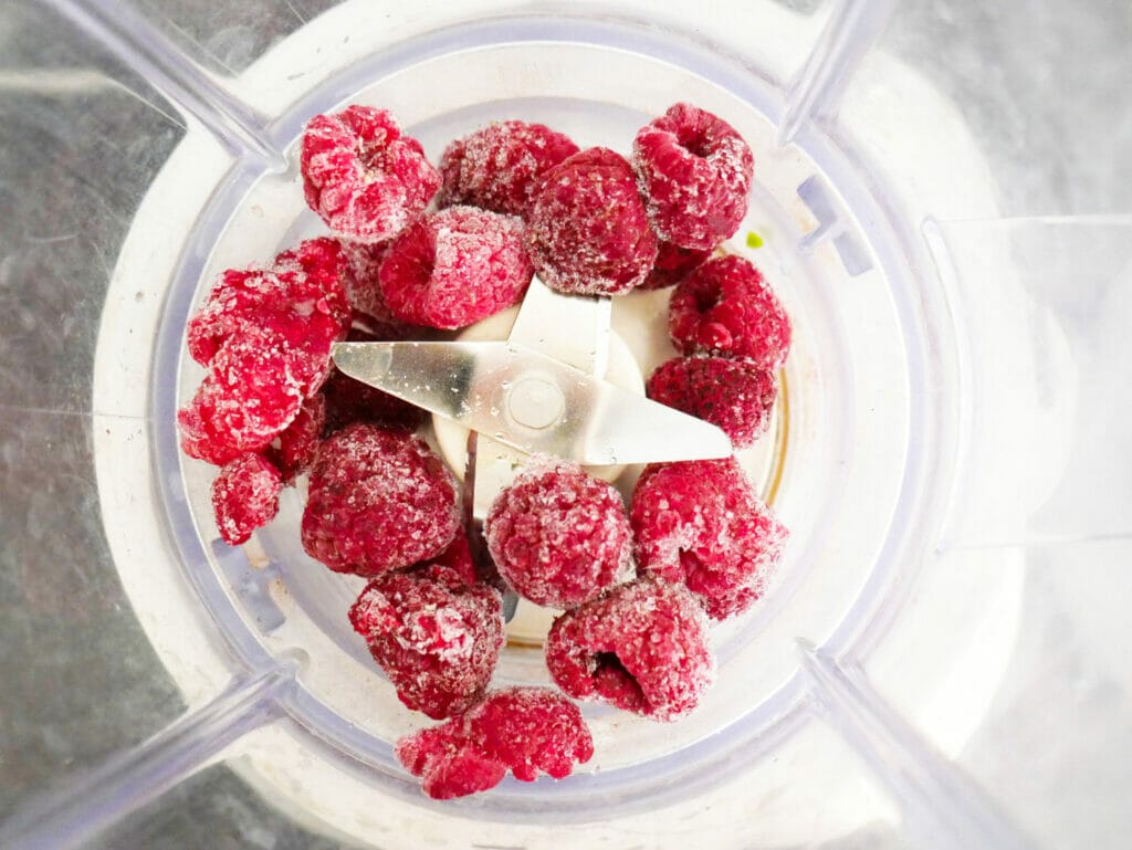 Raspberries in a blender for the almond butter protein shake