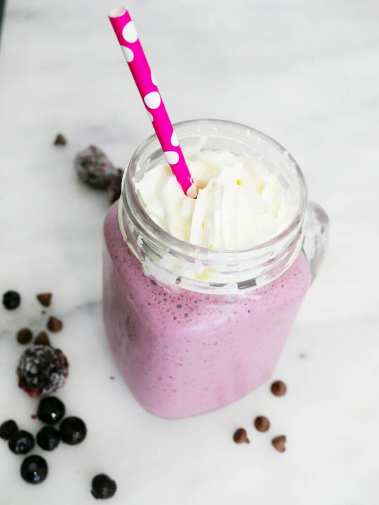 Blueberry blackberry smoothie with chocolate and cream with red straw